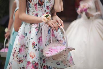 Little bridesmaid with a basket of rose petals. Girls holding rose petals at the wedding ceremony....