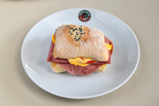 Close-up shot of Izmir's famous Turkish Traditional Kumru Sandwich, &Ccedil;eşme Kumru , ingredients ready to eat salami, sucuk , tomato, cheddar cheese and fried cheese. Yengen eritme karisik sandvic.