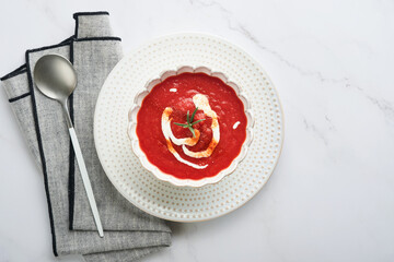 Soup. Tomato cream soup or gazpacho with herbs, seasonings, cherry tomato and parsley in white bowl on light grey stone background. Healthy vegetable soup. Spanish cold soup. Top view with copy space