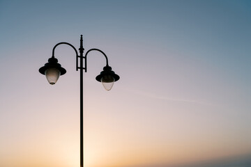 Street double lamp on the background of a colorful sunset