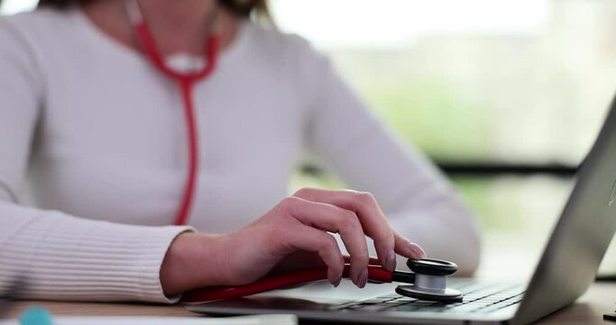 Person doctor puts stethoscope on laptop keyboard