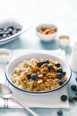 Oatmeal porridge with blueberry, almonds, walnuts, flax seeds, sesame and chia. Healthy vegetarian food for breakfast