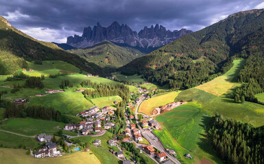 Stunning Alpine scenery of breathtaking Dolomites rocks mountains in Italian Alps, South Tyrol, Italy. Aerial view of Val di Funes and village Santa Maddalena, Valley Isarco - obrazy, fototapety, plakaty
