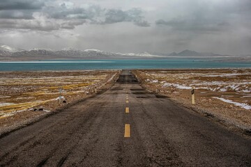 Ali region of Tibet with a winding road, vast mountains, and sprawling fields