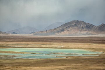 Stunning landscape in the Ali region of Tibet, with majestic mountains and a tranquil blue lake