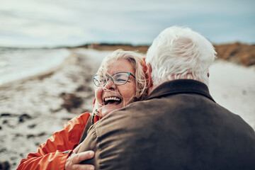 Senior couple hugging on winter beach