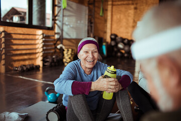 Smiling senior woman working out with friends in gym