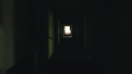 walking down a long dark corridor in an abandoned building