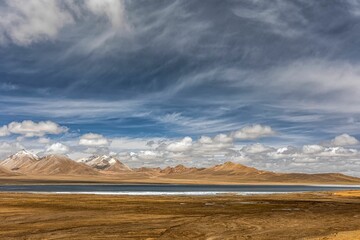 Stunning landscape in the Ali region of Tibet, with majestic mountains and a tranquil blue lake