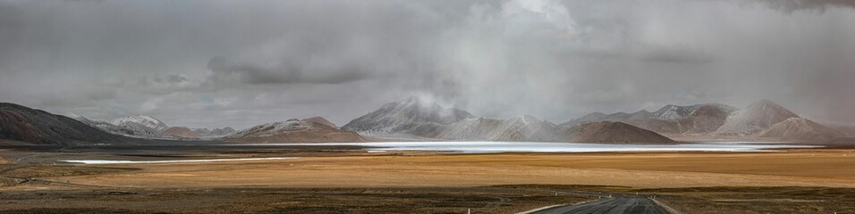 Panoramic view of Ali in Tibet with a landscape of majestic mountains and a serene blue lake