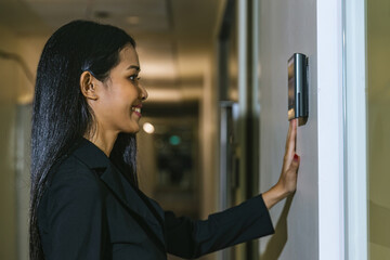 Woman using face scanner to unlock door in office building. Access control facial recognition...