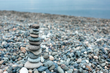 Fototapeta na wymiar Pebble tower on the beach. Relaxing peaceful spa tranquility concept with copy space for text
