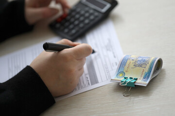 Accountant start to fill Iranian tax form on office table. Taxation period and annual taxpayers routine in Iran