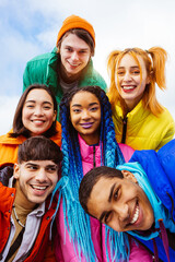 Multiracial group of young friends meeting outdoors in winter - Multiethnic students with colorful...