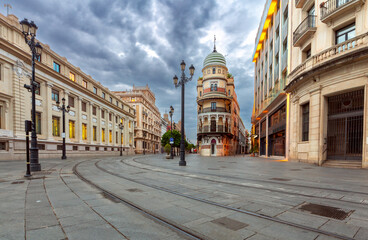 Naklejka premium Constitution Avenue in the light of lanterns in the early morning in Seville.