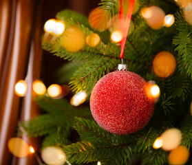 Christmas card. Red glass ball in frost suspended on a Christmas tree