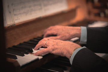 Hands of a old man playing a church organ