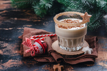 Homemade eggnog with cinnamon in glass on wooden table. Typical Christmas drink