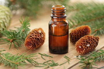 Fir tree essential oil or extract in glass bottle with  cones and wood spruce on wooden rustic...