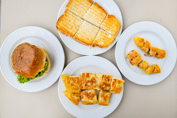 Turkish style meat stuffed filo dough borek served kol boregi. Cheese and minced pie are sliced on a marble background. Turkish name: Kol Boregi, ispanakli, kiymali, Su Boregi