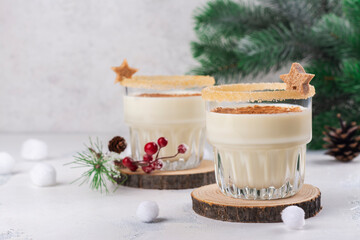 Homemade eggnog with cinnamon in glass on wooden table. Typical Christmas drink
