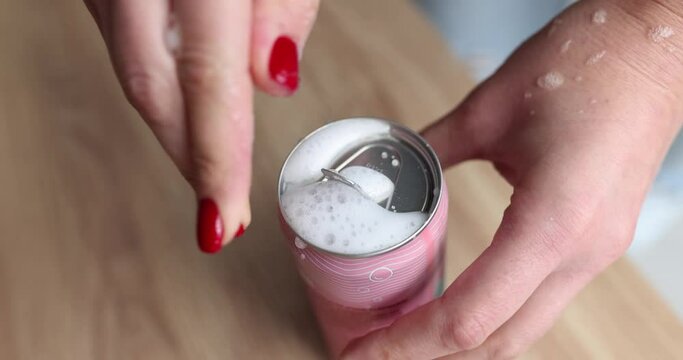 Thirsty woman opens can of shaken drink