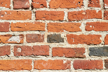 Fototapeta premium Texture of a red brick wall. Wall of an ancient building made of red burnt brick