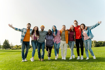 Group portrait of smiling multiracial smiling friends hugging wearing stylish colorful clothes