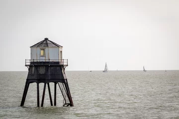 Gartenposter Old lightouse in the sea, Dovercourt low lighthouse, built in 1863 and discontinued in 1917 and restored in 1980 the 8 meter lighthouse is still a iconic sight, with sailing boats sailing past © J.Woolley