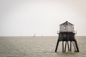 Old lightouse in the sea, Dovercourt low lighthouse, built in 1863 and discontinued in 1917 and restored in 1980 the 8 meter lighthouse is still a iconic sight, with sailing boats sailing past