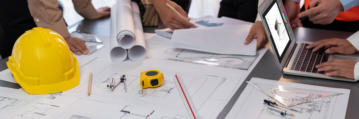 Engineer partner drawing and working on blueprint design together on office table for architectural...