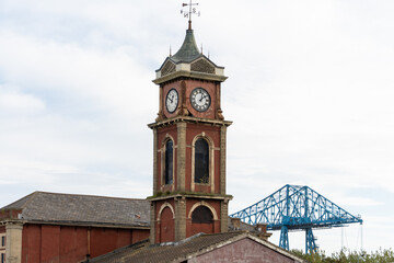 The Old Town Hall, in Middlesbrough, UK, built in 1846 and vacant since 1996, with the Tees Transporter bridge in the background, built 1911. - obrazy, fototapety, plakaty