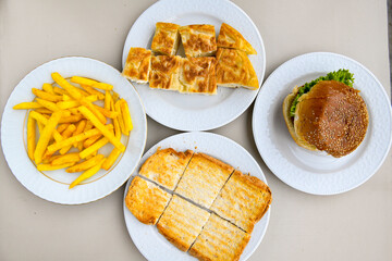 Turkish style meat stuffed filo dough borek served kol boregi. Cheese and minced pie are sliced on a marble background. Turkish name: Kol Boregi, ispanakli, kiymali, Su Boregi