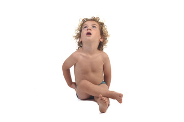front  view of a boy in underpants sitting on the floor lookinp up on white background (3 year old)