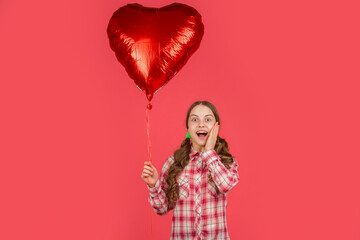 surprised girl hold love heart balloon on red background