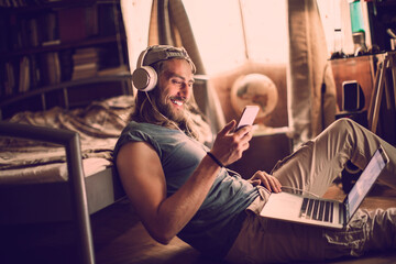 Bearded man listening to music with headphones at home