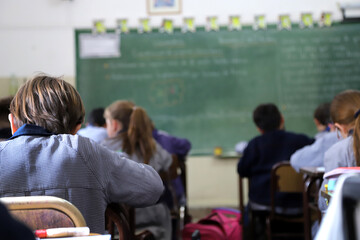 Children learning at school. Primary school students in classes. Students in class at a Catholic school. Boys at their desks dressed in uniform. Education. - Powered by Adobe