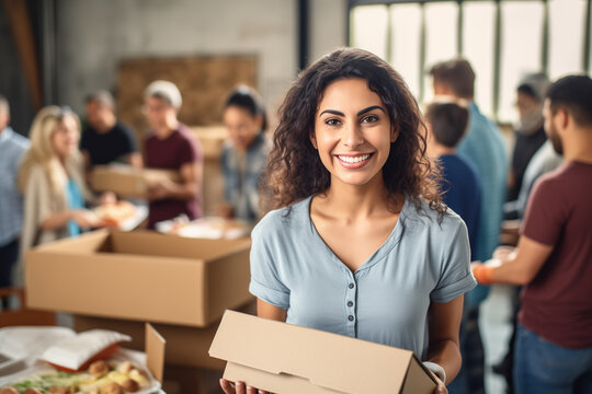 Portrait of woman with charity box and group of volunteers at assistance center. Charity, donation, and volunteering concept.