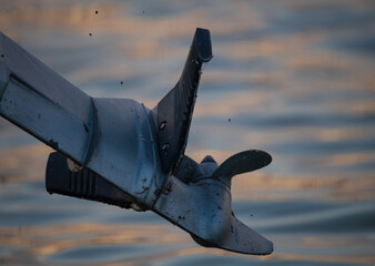 motorboat propeller against the background of the setting sun on the lake