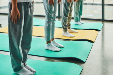 cropped four preadolescent children in sportswear standing on fitness mats, child sport