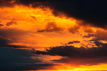 Dramatic sky at sunset, dangerous heavy black orange color clouds in sky, abstract sky and nature background