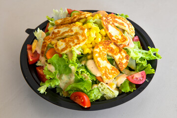 Green salad with arugula, lamb and tomatoes. Healthy vegan dish. Top view at table. Turkish Coban (choban) salata or Shepherds salad, Akdeniz salad in white bowl.