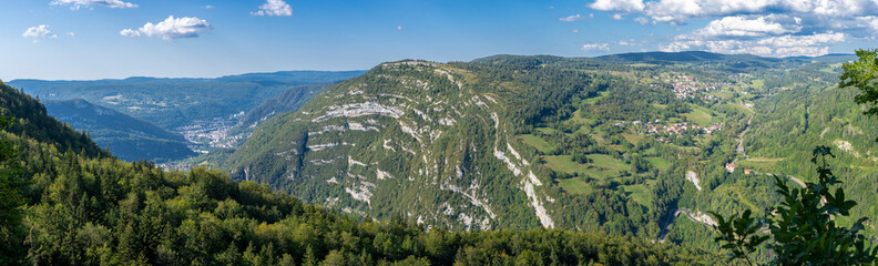 Belvedere La Roche Blanche, France - 09 02 2021: White Rock Belvedere. View of the landscapes of Les Bouchoux with the village Saint Claude, hills, forests and The rocky folds . - obrazy, fototapety, plakaty