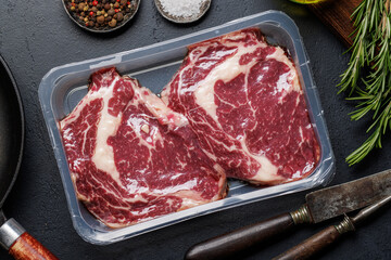 Raw ribeye steaks with savory spices