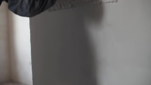 Worker leveling the wall with a trowel