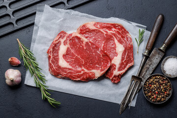 Raw ribeye steaks with savory spices