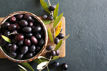Olive nere in una ciotola, nell'olio e nel ramo delle olive. Concetto di cibo sano. Vista...