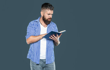 curious bearded man reading book on grey background