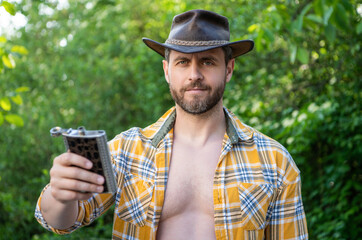 man offer bourbon hipflask wear checkered shirt. photo of cowboy man with bourbon hipflask.