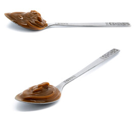 Dulce de leche in a metal spoon on isolated background.